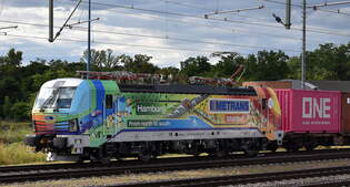 METRANS a.s., Praha [CZ] mit ihrer nagelneuen und wunderschn folierten Vectron  383 443-9  [NVR-Nummer: 91 54 7383 443-9 CZ-MTR] und einem Containerzug am 10.07.25 Hhe Bahnhof Magdeburg