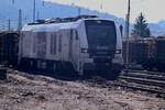 Ins Gegenlicht aufgenommen ist die Stadler Dual von HHPI an der Holzverladung in Neckarelz.