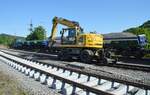 Der abgekippt Schotter wird mit einem Zweiwegebagger (Liebherr 922 rail) verteilt. (Foto vom 13.05. 2025, Ausfahrt Bahnhof Arnsberg Richtung Bestwig)