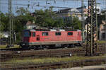 Re 4/4 II 11153 aus der ersten Serie rangiert lange vor der Abfahrt vor den Nightjet. Singen, August 2024.