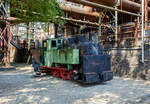 Die 785 mm Schmalspur-Dampflokomotive Nr. 20 der Völklinger Hütte (ehem. Röchling'schen Eisen- und Stahlwerke GmbH in Völklingen/Saar, ab 1982 ARBED-Saarstahl GmbH, ab 1986 Saarstahl Völklingen GmbH) hier am 01 Juli 2025 abgestellt, mit dem Schlackewagen 127 (mit Kübel ARBED 219), als Denkmal beim Biergarten Völklinger Hütte. Heutiger Eigentümer ist die Initiative Völklinger Hütte e.V..

Die Dampflok vom Typ Krauss XXXII kk wurde 1904 von Krauss & Comp. in München unter der Fabriknummer 5168 gebaut und an die RESW - Röchling'sche Eisen- und Stahlwerke AG in Völklingen geliefert und dort als Lok  21  in den Bestand eingereiht. Später tauschte sie mit ihrer Schwesterlok 20 die Betriebsnummer und wurde fortan als Lok  20  eingesetzt. 1978 erfolgte die Aufstellung auf einem Spielplatz in Völklingen-Ludweiler. Im Oktober 1990 übernahm Carreau Wendel vom Musée du bassin houllier Lorrain im französischen Moselle die Lok als Ausstellungsstück. Von dort konnte sie 1997 nach Völklingen zurück und nach einer äußerlichen Aufarbeitung 1998 von der Initiative Völklinger Hütte e.V. in der Alten Völklinger Hütte aufgestellt werden.

Auf dem ehemals 20,4 km langen Schmalspurnetz der Hütte (Spurweite 785 mm) verrichteten bis zu 17 Dampflokomotiven ihren Dienst. Auf der Stahlwerksseite transportierten sie die Schlacke zur Thomasmühle. Die Unterführungen 2 und 3 dienten dem Transport von Stahlblöcken und allgemeinen Gütern zur Versorgung des Walzwerks auf der Eisenwerkseite und dem Abtransport der Walzprodukte. Im Hochofenbereich wurde die Abfuhr der Hochofenschlacke zur Schlackenbrechanlage auf der anderen Saarseite durchgeführt.

Wegen des neuen Stahlwerks, das im Dezember 1980 in Betrieb ging, waren umfangreiche Umbaumaßnahmen notwendig. Der Roheisenkanal wurde tiefer gelegt, die Verbindung zum alten Stahlwerk unterbrochen und im Bereich des Hochofens 6 musste ein neuer Gleisanschluss hergestellt werden. Dadurch musste für die schmalspurige Schlackenbahn eine Hubbrücke gebaut werden, da sich Schmalspurgleis und Roheisengleis auf unterschiedlichem Niveau befinden.

Die baugleiche Lokomotive 21 ist auch vorhanden, sie steht mit zwei Schlackenwagen am Ausgang des Schlackenkanals auf der abgesenkten Hubbrücke in Richtung Schlackenbrechanlage. Leider konnte ich diese nicht entdecken.

TECHNISCHE DATEN der Lok 20 und 21 
Hersteller: Krauss & Comp., München
Typ: XXXII kk
Baujahr: 1904
Spurweite: 785 mm (Schmalspur)
Achsfolge: B
Länge: 5.400 mm
Achsabstand: 1.400 mm
Triebraddurchmesser: 680 mm (neu)
Breite: 1.800 mm
Höhe: 2.650 mm
Dienstgewicht: 16 t
Höchstgeschwindigkeit: k. A. 
Leistung: 80 PS
Zugkraft: 3 t
Zylinder: 2 Stück, Ø 260 mm x 380 mm Hub
Dampfdruck: 14 bar
Heizfläche: 20,62 m²
Rostfläche: 0,43 m“
Anzahl Siederohre: 80 Stück
Durchmesser Siederohre: 39/42 mm
Länge Siederohre: 2.510 mm
Wasservorrat: 1.400 l (1,4 m³)
Kohlenvorrat: 300 kg