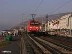 Wrend 185 077-5 mit ein Containerzug durch Rdesheim an dem Rhein fhrt,wartet eine Gruppe Japaner auf ihr Schiff. 13.02.08