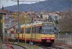 Die Strassenbahn  Be 4/8 003  alias 94 800 450 003-9 D-TVYS ist auf dem Weg nach Orbe bereits inmitten des gößeren Industriegebiets der Kleinstadt. Gleich ist der Haltepunkt Les Granges erreicht, der der eigentliche große Bahnhof dieser Kleinbahn ist. Dezember 2025.