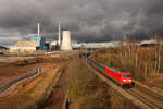 Am 1. Februar 2024 passiert 152 016-2 mit einem vollen Drahtrollenzug das Kraftwerk Ensdorf bei beeindruckender Wolkenkulisse. Das Motiv ist seit dem 30. Juni so nicht mehr umsetzbar, da die Türme gesprengt wurden und nun nur noch der Gebäudekomplex am linken Bildrand steht.