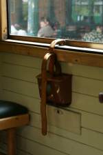Ein Lederriemen - frher auch zur Zchtigung Unerzogener verwendet, dient er heute noch zum Arretieren in verschiedenen Stellungen der zu ffnenden Fenster in den Reisezugwagen des Rasenden Rolands.
(Juni 2009)