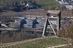 Mit Olli auf Motivsuche in Schaffhausen - 

Ein lange steile Treppe sind wir auf der Züricher Seite des Rheines hochgestiegen zu einem kleinen Weinberg nördlich von Flurlingen. Während der Blick auf die Strecke in Richtung Schweiz teilweise von Gebäuden und Bäumen verdeckt ist, hat man doch einen freien Blick auf die Hochrheinbahn nach Basel. 

Hier ist eine Bahn der S65 der S-Bahn Schaffhausen auf dem Weg nach Erzingen (Baden) unterwegs. Markant der Pylon der Schrägseilbrücke der A4 über den Rhein, der hier hochragt.

09.03.2025