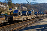 6-achsige Drehgestell-Flachwagen mit aufgesetzten Lademulden für Coils (Blechrollen), hier im Vordergrund 31 80 4871 100-2 D-DB, der Gattung Sahmms-t 710, der DB Cargo Deutschland AG, am 21 November 2025 im Zugverband bei der Zugdurchfahrt in Ki ...
