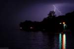Donnerwetter am See - Mein Vorschlag: Leichte Aufhellung der vom Blitz erleuchteten Region, die Wolke und der See bleiben schwarz. Der Blitz kommt aus dem dunklen Nichts, die Spiegelung der Lichter bleibt weitgehend erhalten. Wer bietet mehr?