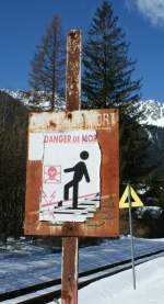 Das ursprngliche Schild ist seit langem verbleicht und auch das darber geklebte knnte eine Auffrischung gebrauchen. 
Warung vor den Gefahren der Stromschiene in Chamonix (12. Mrz 2009)