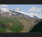 Der Zug wirkt sehr klein in dieser groartigen Landschaft. Die Streckenfhrung gibt fr den Ortsfremden vielleicht Rtsel auf: wo kommt ist denn das andere Ende des Tunnels? Glacier-Express auf der Strecke der Matterhorn Gotthard Bahn oberhalb von Andermatt. Das Bild wurde im DSO-Fotoforum in die Hall of Fame gewhlt. (Matthias)