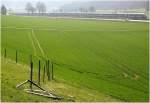 Ein Bahn-/Landschaftsbild, aber in ungewhnlicher Aufteilung. Unten viel Feld mit den Traktorspuren und oben, eher schon im Hintergrund und im Gegenlicht der ICE-Zug. Die Aufnahme entstand zwischen Amstetten und Ursping an der Strecke Stuttgart - Ulm.