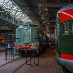 Die Elektrolokomotive NS 1201 der NS-Baureihe 1200 am 24 Juni 2025 im Het Spoorwegmuseum (bis 2005 NSM - Nederlands Spoorwegmuseum / Niederländischen Eisenbahnmuseum) in Utrecht im ehemaligen Bahnhof Maliebaan. Ein Eisenbahnmuseum das zum Verweilen einlädt.

Die Lok wurde 1951 von Werkspoor in Utrecht unter der Fabriknummer 928 gebaut (Baldwin-Lizenz) und an die NS - Nederlandse Spoorwegen (Niederländischen Staatsbahnen, heute Niederländische Eisenbahnen AG) geliefert. Wobei die Entwicklung und Konstruktion, sowie auch einige Teile, von Baldwin Locomotive Works in Philadelphia (USA) stammt. Auch die Entwicklung der Elektrotechnik stammt aus den Vereinigten Staaten und zwar von Westinghouse Electric Corporation (Monroeville), diese wurde von Heemaf in Hengelo (Westinghouse-Lizenz) geliefert.

Die Baureihe 1200 der Niederländischen Eisenbahnen (NS) ist eine sechsachsige Elektrolokomotivbaureihe aus den Jahren 1951 bis 1953. Die Lokomotiven waren bis 1998 bei der NS im Einsatz.

Die Nase war der erste Teil dieser unglaublich starken und robusten Lokomotive, der ins Auge fiel. Sie sollte dem Lokführer bei Kollisionen einen besseren Schutz bieten. Diese Lokomotiven wurden in den Niederlanden nach einem amerikanischen Design und mit einigen amerikanischen Teilen gebaut, die teilweise durch amerikanische Dollar über den Marshall-Plan finanziert wurden. Die NS nutzte diese Lokomotiven, um sowohl Personenzüge als auch Güterzüge zu ziehen. Ihre wichtigste Aufgabe war es Schnellzüge zu ziehen. Als sich die NS 1995 trennte, wurden alle 1200er Jahre an NS Cargo übertragen und begannen im Güterverkehr zu arbeiten. 

Nach Ende des Zweiten Weltkrieges gab es großen Fahrzeugmangel bei der NS. Da man keine Erfahrungen mit dem Bau elektrischer Lokomotiven hatte, kaufte man Lokomotiven bei verschiedenen Lieferanten. Die bei Baldwin konstruierten Lokomotiven wurden bei Werkspoor in Utrecht gefertigt. Die bei Westinghouse entwickelte Elektrotechnik wurde von Heemaf in Hengelo geliefert. Von den ursprünglich 75 georderten Lokomotiven wurden nur 25 ausgeliefert. Der amerikanische Einfluss ist an den hochliegenden Führerständen und den großen, dem Schutz des Lokführers dienenden Vorbauten erkennbar. Am 30. November 1950 wurden 25 Loks bestellt, am 27. September 1951 konnte die erste Probefahrt stattfinden. Am 9. Februar 1952 wurde die 1201 offiziell in Dienst gestellt, der Preis pro Lok betrug 765.000 NFL (ca. 347.000 Euro).

Die Loks hatten sechs Motoren des Typs TM94. Die ersten 14 Lokomotiven waren türkis lackiert, danach setzte sich wegen des sichtbaren Abriebs der Stromabnehmer eine rotbraune Farbgebung durch. Ab 1954 erhielten alle Loks eine blaue Farbgebung, 1971 erhielt die erste Lok die neuen NS-Hausfarben grau/gelb, 1983 war auch die letzte Lok entsprechend umlackiert. Am 30. März 1998 endete der planmäßige Einsatz bei der NS.

Fünf weitere Lokomotiven (1214, 1215, 1218, 1221, 1225) wurden 1999 an die ACTS Nederland BV verkauft. Diese vermietete 2010 drei Lokomotiven (1214, 1215, 1225) an die Eisenbahngesellschaft Euro-Express Treincharter (EETC). Von der wurden sie bis April 2015 unter anderem vor den Nachtzügen Niederlande–Österreich zwischen Amsterdam und Venlo eingesetzt. Fünf Maschinen (1201, 1202, 1211, 1218, 1221) sind als Museumslokomotiven erhalten. NS 1211 ist Botschafterlok im Bahnpark Augsburg. Leihgeber ist das Eisenbahnmuseum Utrecht.

TECHNISCHE DATEN:
Hersteller mech.: Werkspoor (in Lizenz von Baldwin)
Hersteller Elektrik: Heemaf (in Lizenz von Westinghouse)
Baujahre: 1950 bis 1953
Ausmusterung bei NS: bis 1998 
Gebaute Anzahl: 25
Nummerierung: NS 1201 bis 1225
Spurweite: 1.435 mm (Normalspur)
Achsfolge: Co’Co’ 
Länge über Puffer: 18.086 mm
Höhe: 4.064 mm
Treibraddurchmesser: 1.100 mm (neu)
Dienstgewicht: 108 t
Antriebsmotoren: 6 Stück Heemaf vom Typ TM 94
Getriebeübersetzung: 20 : 71
Höchstgeschwindigkeit: 130 km/h (Planmäßig) / 150 km/h (technisch möglich)
Stundenleistung: 6 x 392 kW = 2.350 kW
Dauerleistung: 6 x 367 kW = 2.200 kW
Anfahrzugkraft: 195 kN
Dauerzugkraft: 164 kN bei 80 km/h / 64,7 kN bei 123 km/h
Stromsystem: 1,5 kV DC (=)
Kleister befahrbarer Gleisbogen: R 100 m