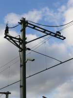 Oberleitungmast mit viele Extra's. Wie ein Kamera womit die Fahrdienstleitung der neben liegende Bahnbergang beobachten kann. Weiter noch der eigentlich Ein/Aus Oberleitungschalter wo ber ich in mein Kommentar schrieb bei Bild 10664.