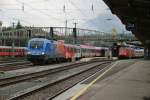 Deutsch-stereichische Begegnung im Bahnhof Salzburg! Whrend die Feuerwehrlok mit einem bunt gemischten Personenzug von Gleis 5 ausfhrt, mu die deutsche 101 112-1 auf Gleis 4 noch warten! Aufgenommen am 10.10.09.
