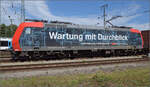 Re 482 012 mit 'Wartung mit Durchblick'-Werbung in Singen. August 2024.