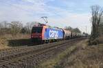 SBB Cargo 482 025 schleppt ein Kesselwagenzug durch Kaarst-Broicherheide am 21 Februar 2025.
