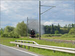 150 Jahre Emmentalbahn. 

141-R-1244 auf dem Rückweg von der grossen Emmentalrundfahrt anlässlich des Jubiläums. Am Ortsausgang Menznau findet die Sonne ein Wolkenloch, freie Sicht auf die Strecke und die Strasse ist ohne Verkehr. Menznau Tuetisee, Mai 2025.