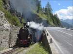 HG 4/4 704 erklimmt mit ihrem Zug die Rampe von Oberwald nach Gletsch. Hier kommt sie aus dem Kreiskehrtunnel wieder raus. August 2025.