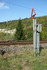 Das rote Dreieck macht den Schneepflug-Fahrer darauf aufmerksam, hier an dieser Stelle den Pflug anzuheben, da sonst sich im Gleis befindlicher Einrichtungen Schaden nehmen knnten. In diesem Fall handelt es sich um Signum-Magnete, die, so das Schild links im Bild, den Lokfhrer warnen, falls die Barriere nicht geschossen ist. 
Bei Le Pont, 4. Okt 2009