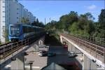 Hsselby grd, Grne Linien (T19). Blick in Richtung Hsselby Strand. Aufgrund der Mittelbahnsteige werden die Gleise im Bereich der Stationen auseinandergezogen und oftmals werden so wie hier auf zwei getrennten Brckenbauwerken bei den Stationen Straen gekreuzte. Das Zugangsgebude liegt dann am Ende des Bahnsteiges zwischen den Gleisen. Bei der Stockholmer U-Bahn herrscht Linksverkehr, hier also ein Nachschuss. 25.07.2008 (Jonas)